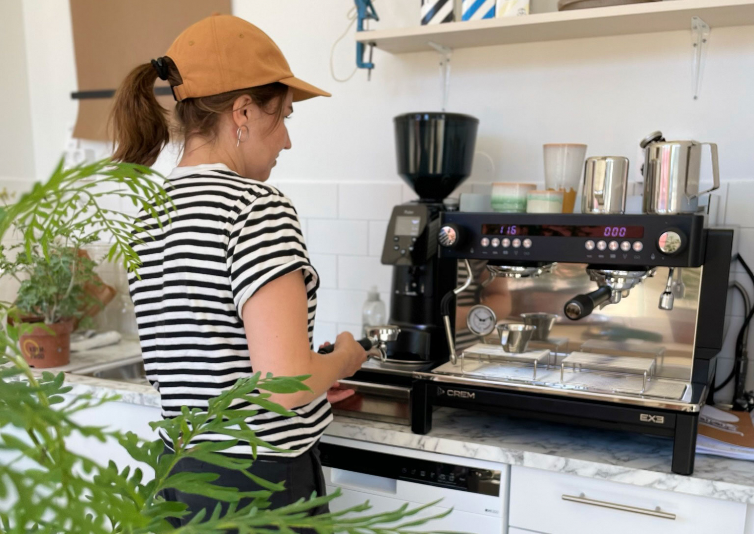 Maria värmer upp kaffemaskinen inför öppnandet